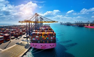 Aerial view of cargo ship and cargo container in harbor.