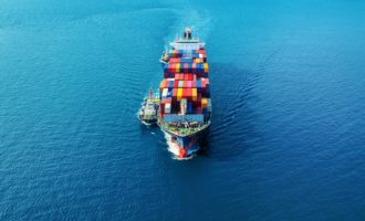 Aerial view of cargo ship with cargo container on sea.